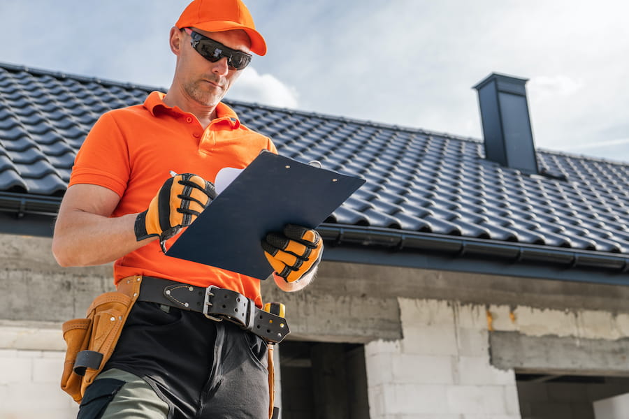 roofing professional inspecting shingles for storm damage