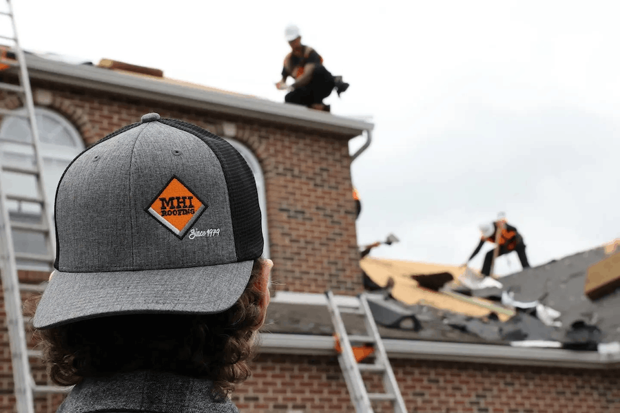 contractor evaluating storm damage on residential roof