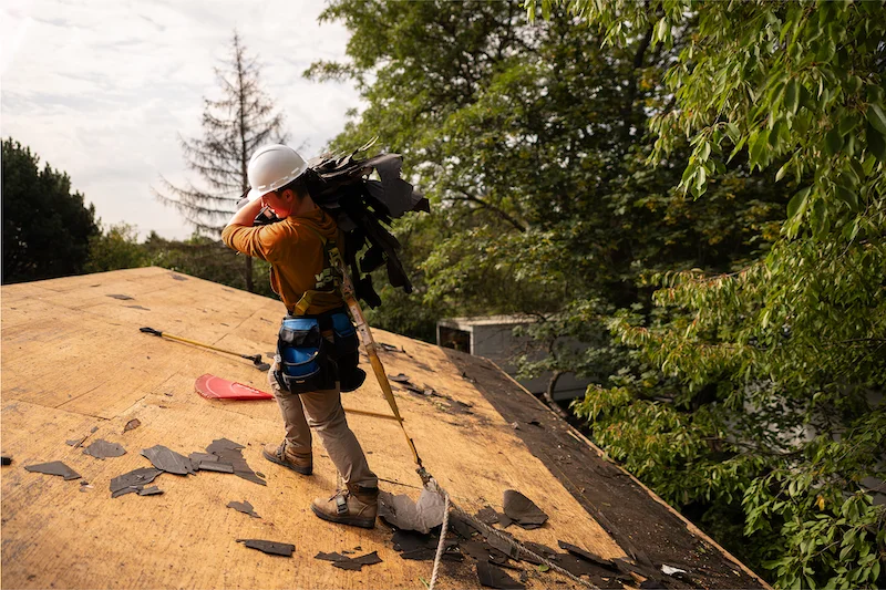 contractor evaluating storm damage on residential roof