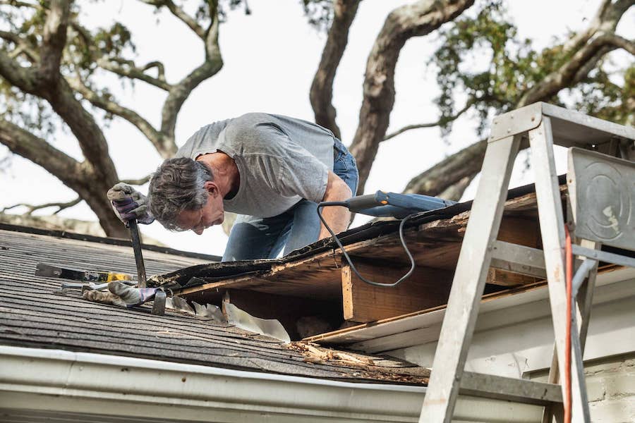 Roofing contractor installing asphalt shingles on a residential home
